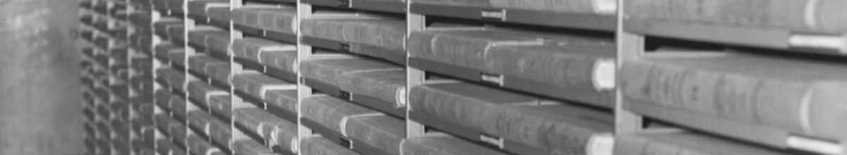 Archive photograph of bound ledger volumes stacked in rows on open shelving.
