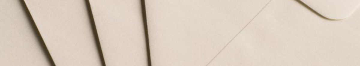 Several plain cream envelopes overlapping on a flat surface.